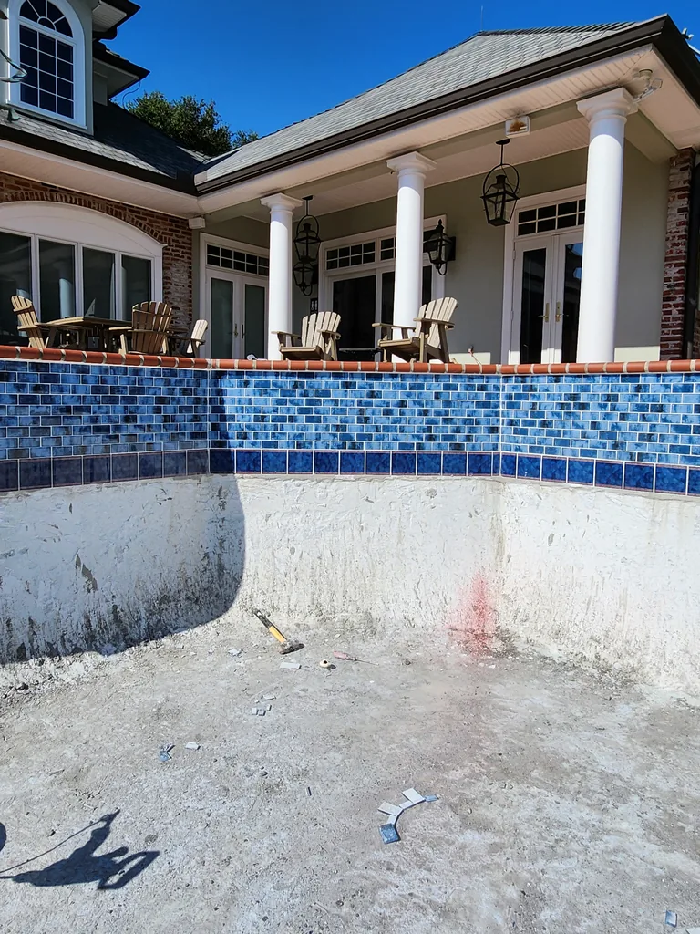 Rough pool interior with tools and debris during surface preparation in Bourg, Louisiana