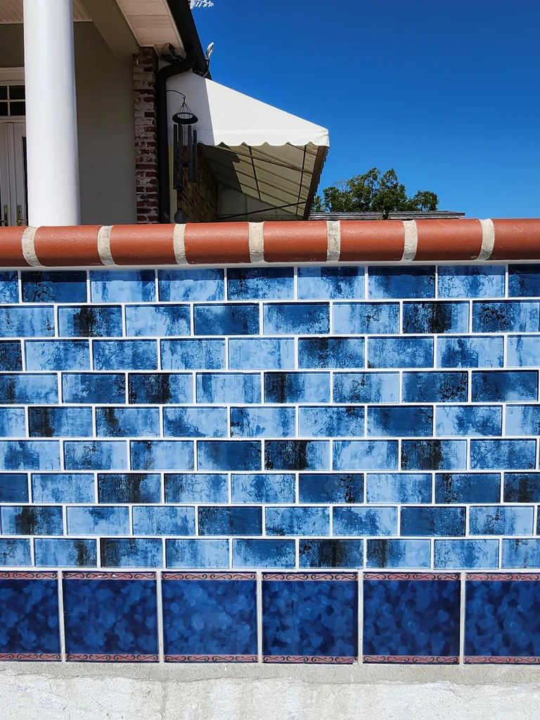 Close-up of blue pool tile, grout lines and brick coping during renovation in Bourg, Louisiana
